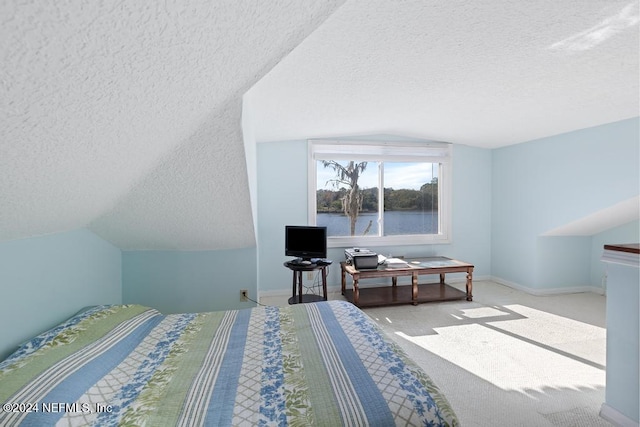 bedroom featuring light colored carpet, a textured ceiling, and vaulted ceiling