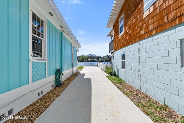 view of home's exterior with a patio area and a water view