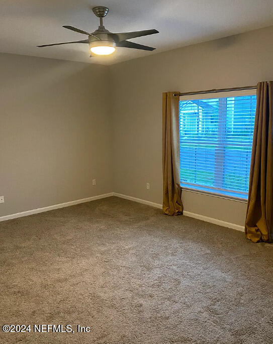 carpeted empty room featuring ceiling fan