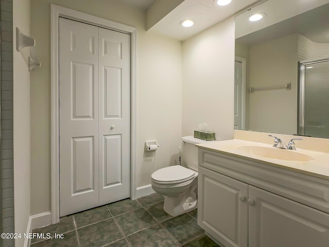 bathroom featuring tile patterned floors, vanity, toilet, and a shower with door