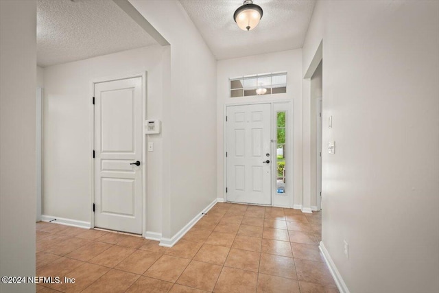 tiled entrance foyer featuring a textured ceiling