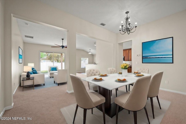 carpeted dining space featuring ceiling fan with notable chandelier