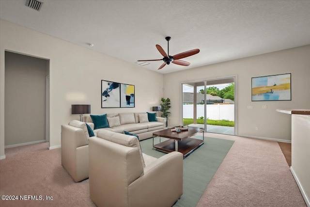 carpeted living room featuring ceiling fan and a textured ceiling