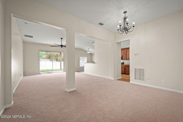 carpeted empty room featuring ceiling fan with notable chandelier and a textured ceiling