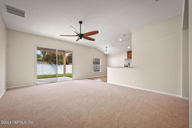 unfurnished living room with light carpet, a textured ceiling, vaulted ceiling, and ceiling fan