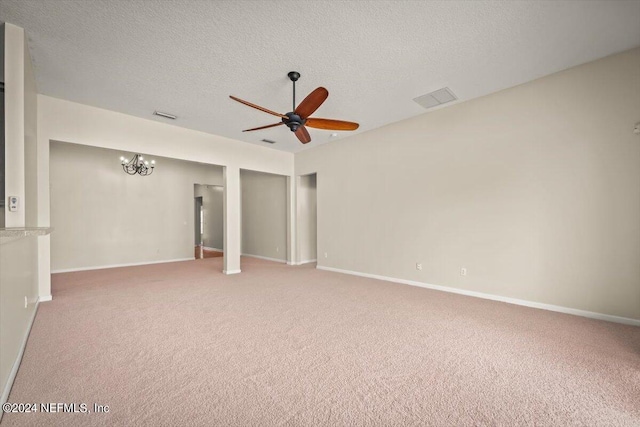 empty room featuring ceiling fan with notable chandelier, a textured ceiling, and carpet floors