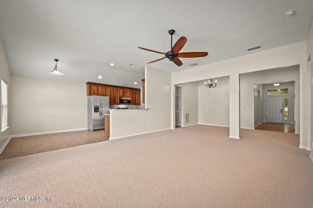 unfurnished living room with light carpet, a textured ceiling, and ceiling fan