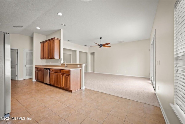 kitchen with light carpet, appliances with stainless steel finishes, a textured ceiling, ceiling fan, and sink