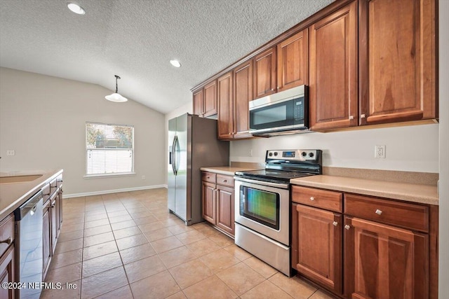 kitchen featuring a textured ceiling, light tile patterned floors, lofted ceiling, and appliances with stainless steel finishes