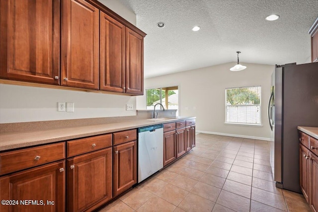 kitchen with appliances with stainless steel finishes, vaulted ceiling, sink, light tile patterned floors, and hanging light fixtures