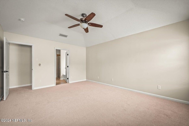 unfurnished bedroom with a textured ceiling, ceiling fan, light carpet, and lofted ceiling