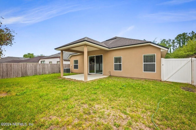 back of house featuring a yard and a patio area