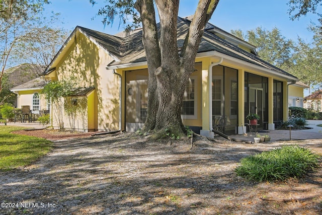 view of front of home with a sunroom and a patio