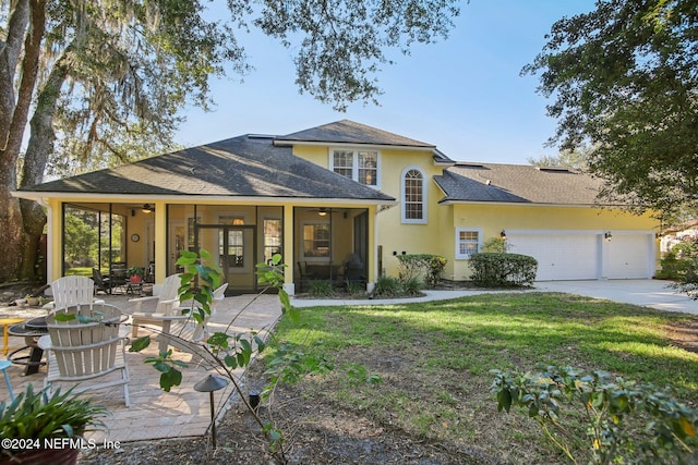 view of front of property featuring a sunroom, a garage, and a front lawn