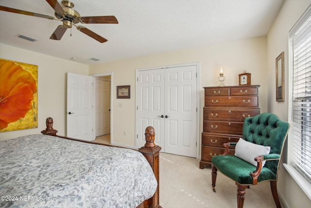 bedroom featuring ceiling fan, light colored carpet, and a closet