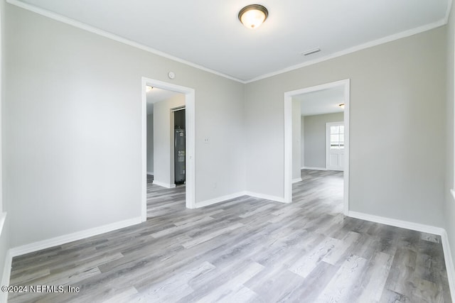 unfurnished room with light hardwood / wood-style floors and crown molding