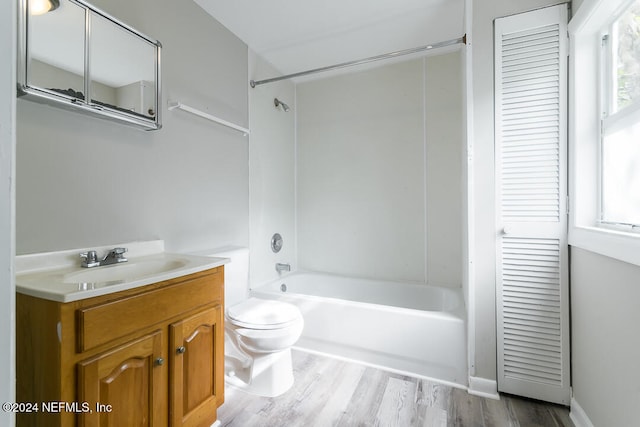 full bathroom featuring hardwood / wood-style floors, vanity,  shower combination, and toilet