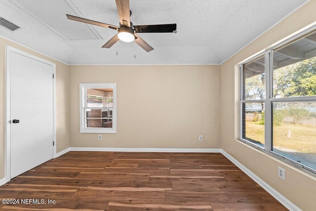 empty room featuring vaulted ceiling, ceiling fan, dark wood-type flooring, and a textured ceiling