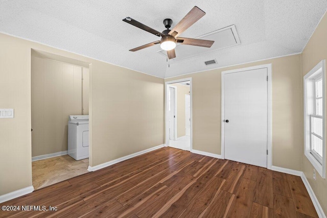 unfurnished bedroom with a textured ceiling, ceiling fan, washer / dryer, connected bathroom, and dark hardwood / wood-style floors