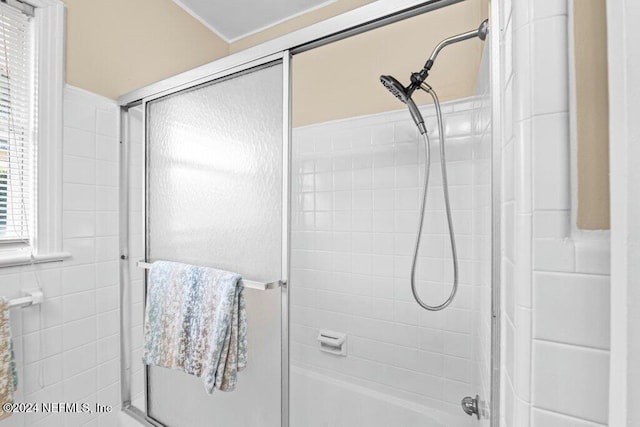 bathroom featuring bath / shower combo with glass door