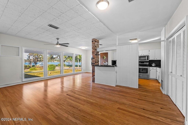 unfurnished living room featuring ceiling fan and light hardwood / wood-style flooring