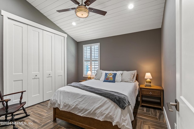 bedroom featuring dark parquet flooring, ceiling fan, a closet, and lofted ceiling