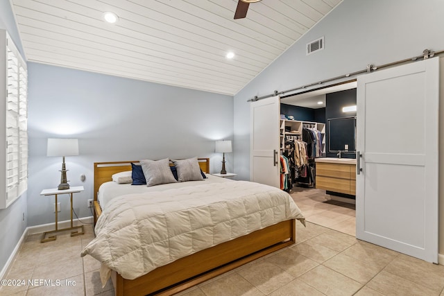 bedroom featuring a walk in closet, ceiling fan, a barn door, wood ceiling, and a closet