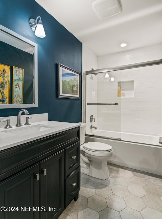 full bathroom featuring tile patterned flooring, vanity, enclosed tub / shower combo, and toilet