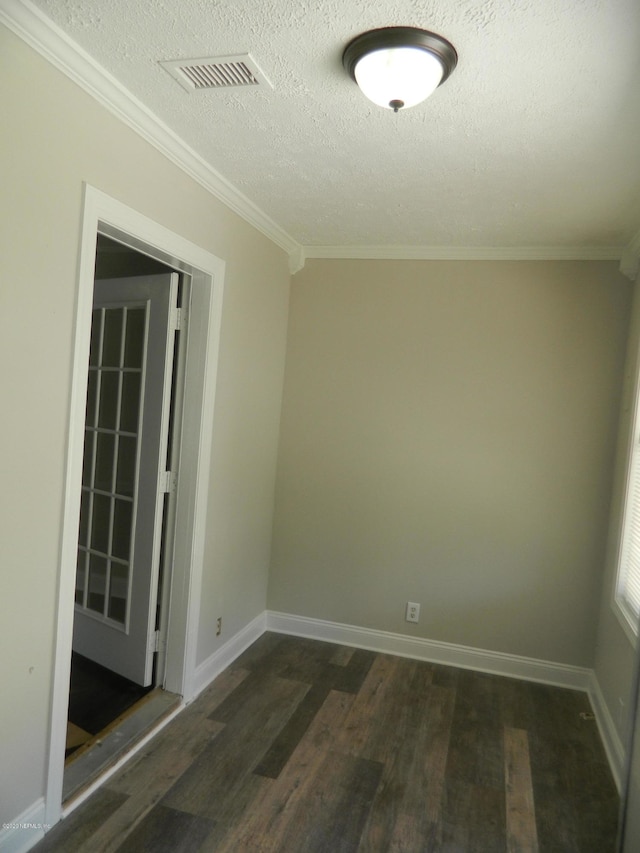 empty room with a textured ceiling, dark hardwood / wood-style floors, and ornamental molding