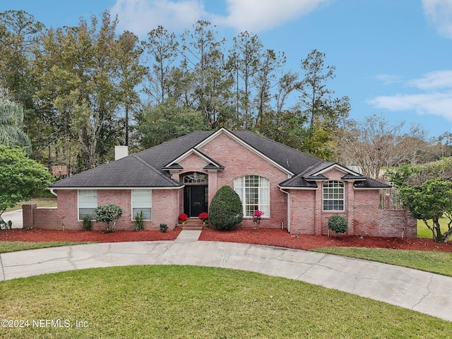 single story home featuring a front lawn