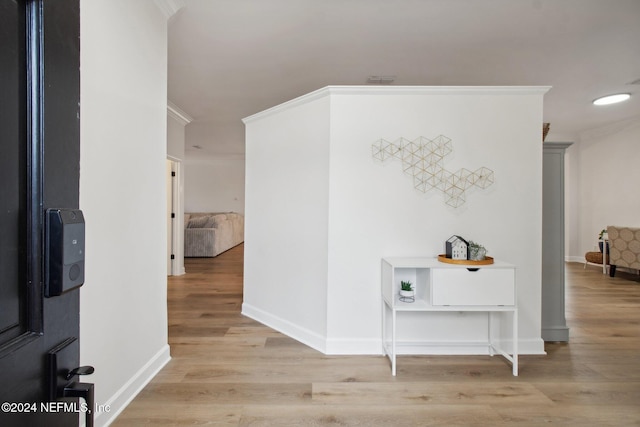 corridor featuring crown molding and light hardwood / wood-style flooring