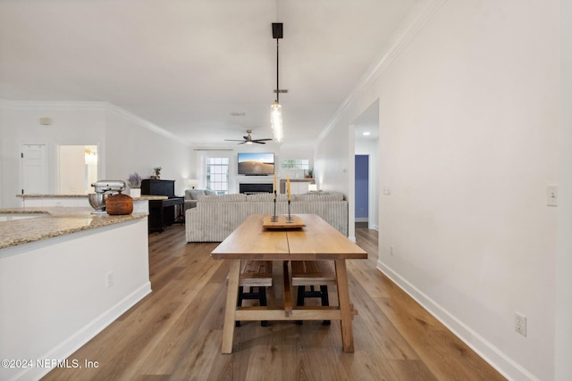 dining area with light wood-type flooring, ceiling fan, and crown molding