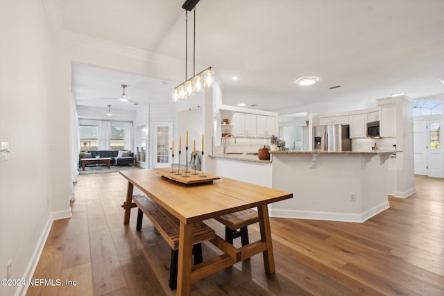 dining area with crown molding, sink, ceiling fan, and hardwood / wood-style flooring