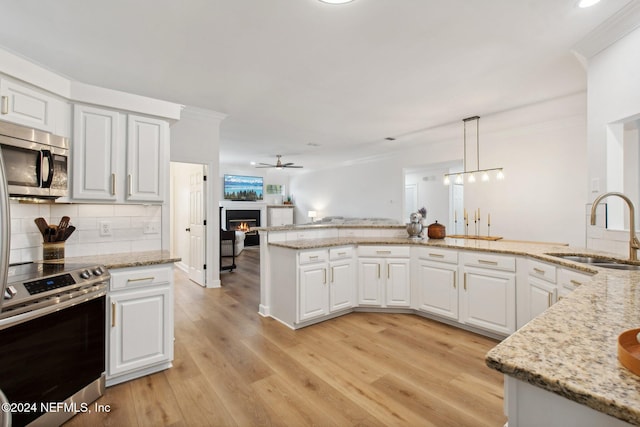 kitchen with stainless steel appliances, white cabinetry, light hardwood / wood-style floors, and sink