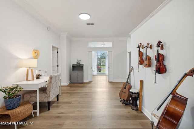 foyer featuring ornamental molding and light hardwood / wood-style flooring