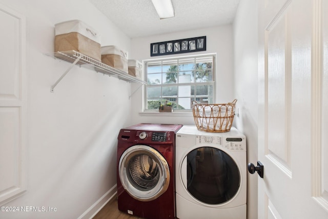 laundry room featuring hardwood / wood-style floors, washing machine and dryer, and a textured ceiling