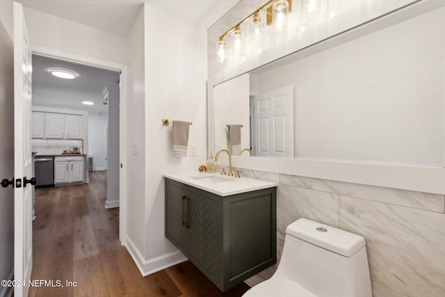 bathroom with hardwood / wood-style floors, vanity, toilet, and tile walls