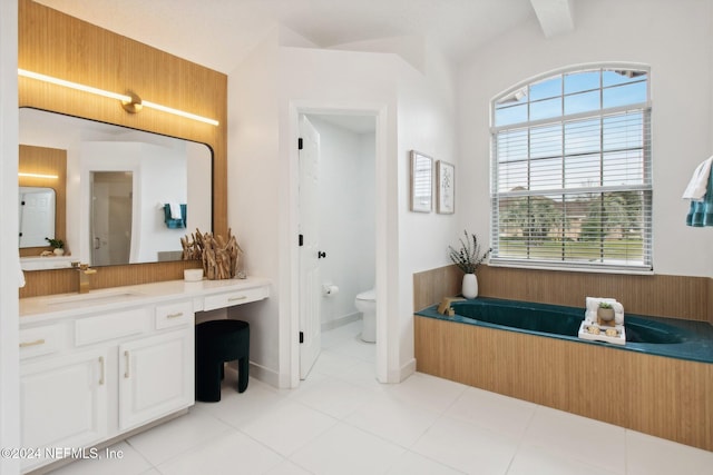 bathroom featuring vanity, beam ceiling, tile patterned flooring, toilet, and a tub