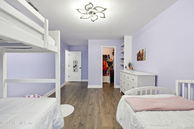 bedroom with dark hardwood / wood-style floors, a walk in closet, and a closet