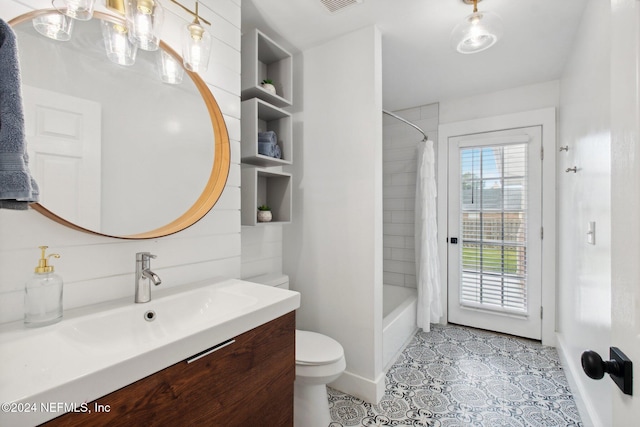 full bathroom with tile patterned flooring, shower / bath combo with shower curtain, vanity, and toilet