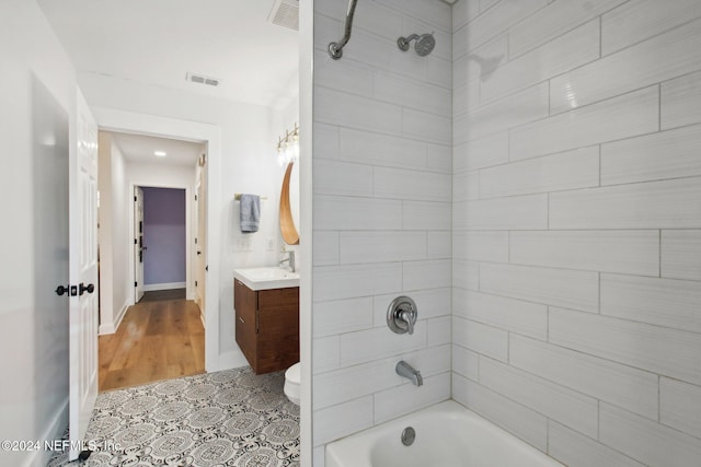 full bathroom featuring vanity, toilet, wood-type flooring, and tiled shower / bath