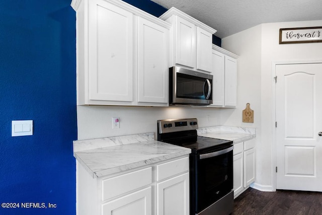 kitchen with a textured ceiling, white cabinetry, stainless steel appliances, and dark hardwood / wood-style floors