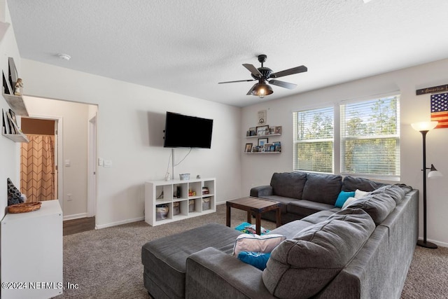 carpeted living room with ceiling fan and a textured ceiling