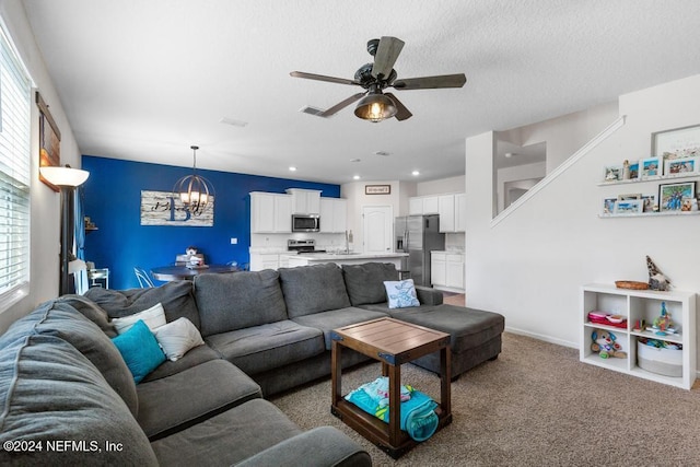 carpeted living room with ceiling fan with notable chandelier, sink, and a textured ceiling