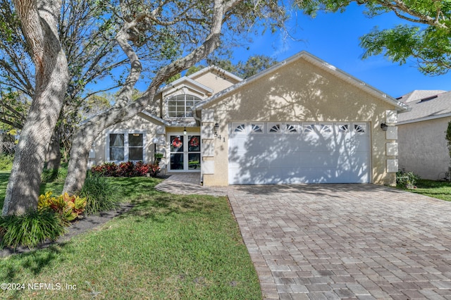 view of front of property featuring a garage and a front lawn