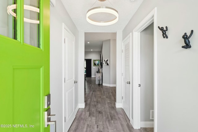 hall featuring baseboards and wood finished floors