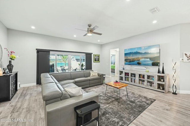 living room with recessed lighting, visible vents, baseboards, and wood finished floors