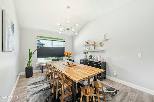 dining area featuring a notable chandelier, baseboards, vaulted ceiling, and wood finished floors