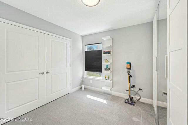 unfurnished bedroom featuring carpet, baseboards, and a closet