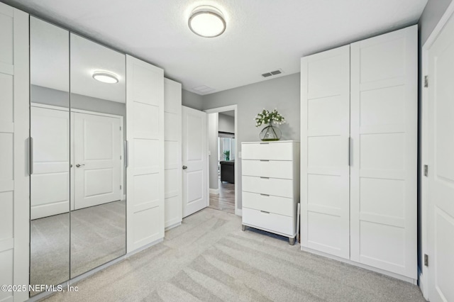 unfurnished bedroom with visible vents and light carpet